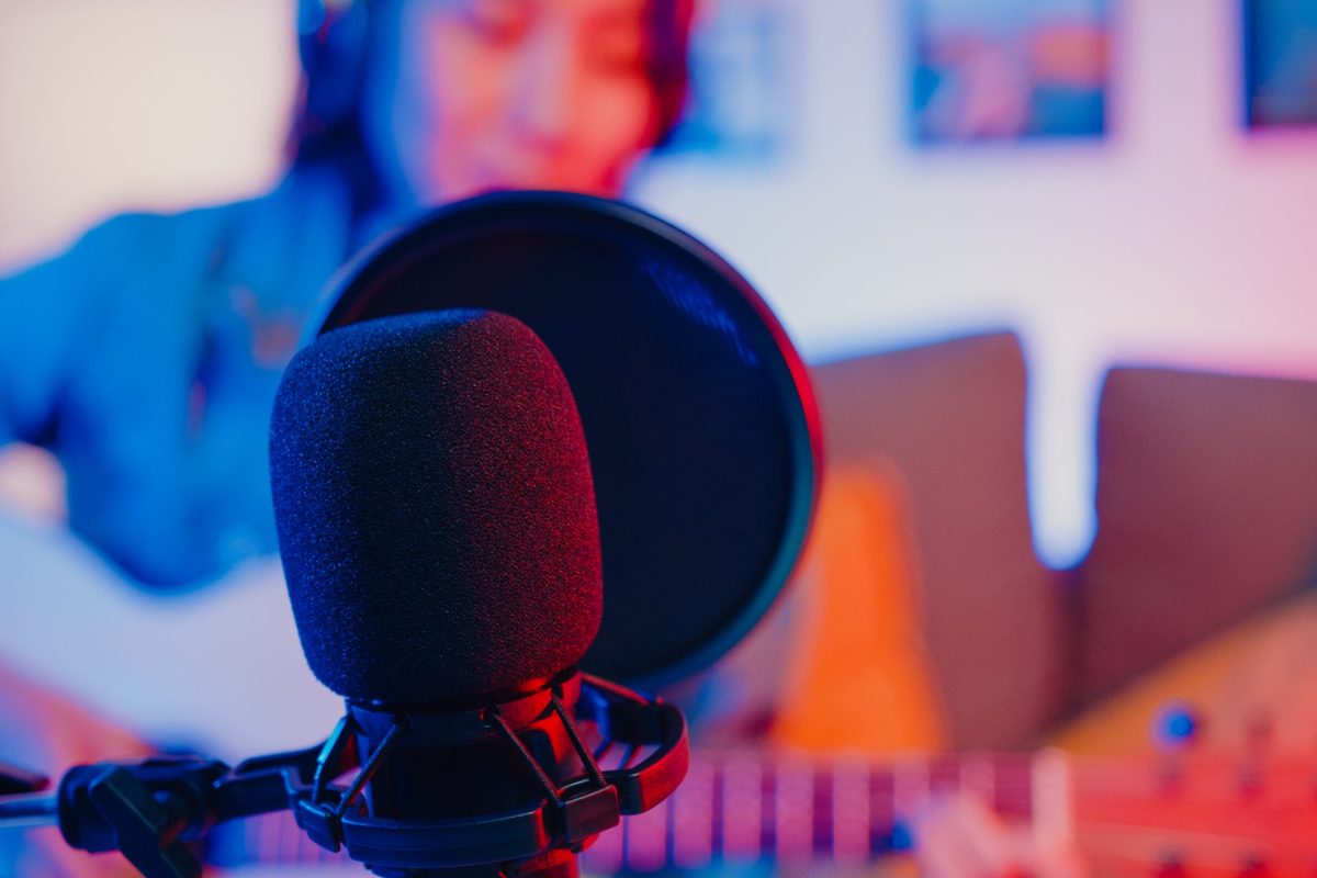 Happy asia girl blogger play guitar and use microphone sing song record music sound mixer on laptop in modern living room home studio at night. Music content creator, Tutorial, Broadcast concept.